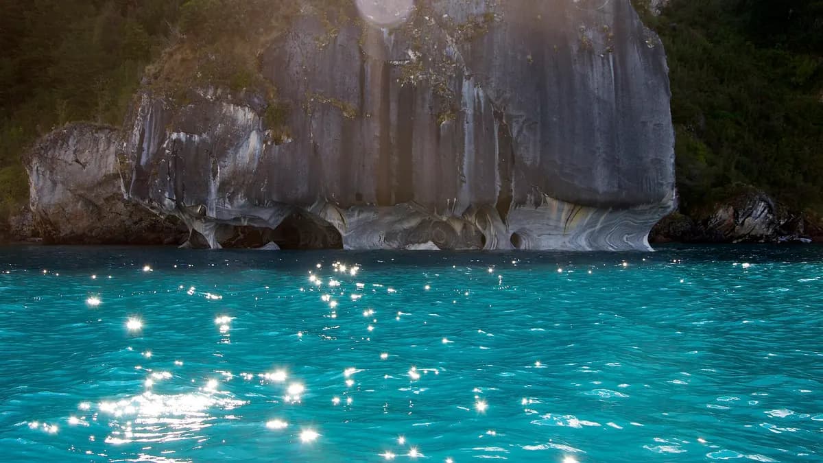 Formaciones de roca blanca y gris en la orilla del lago con aguas turquesa
