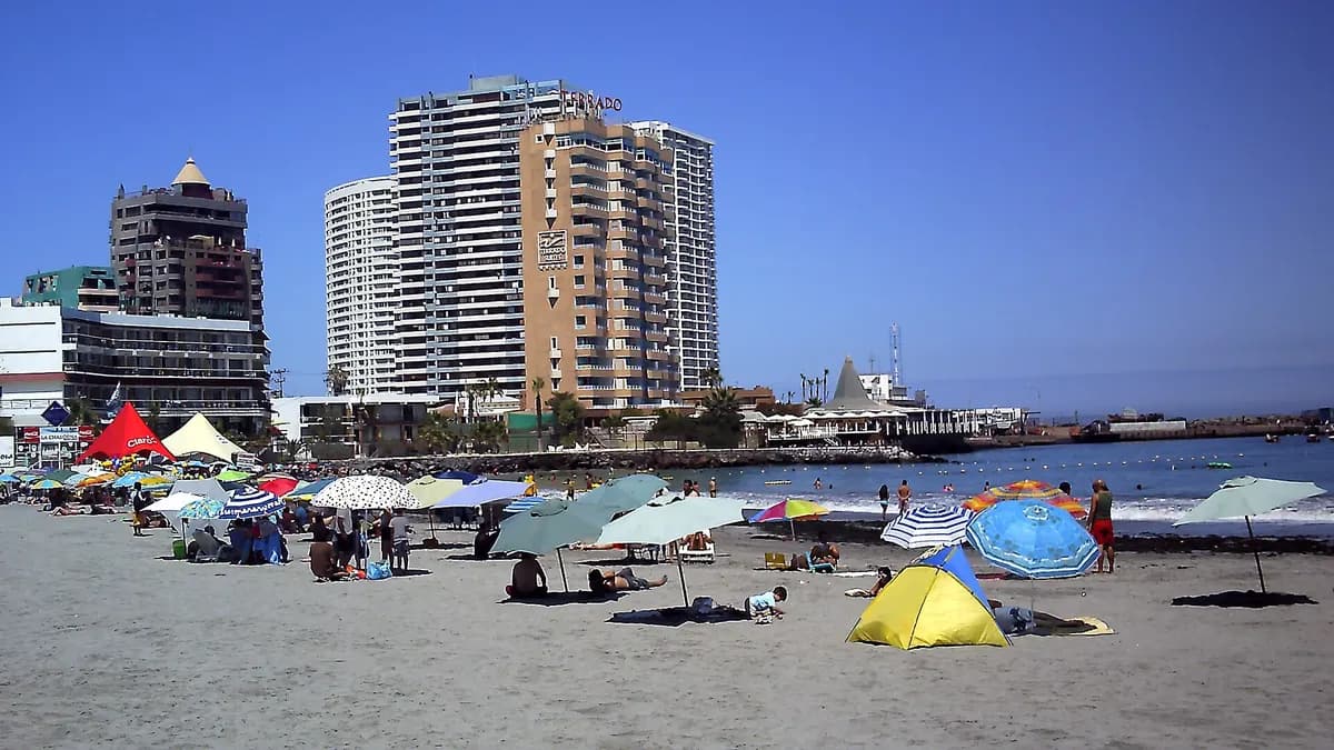 Playa Cavancha de Iquique con bañistas y edificios en la costanera