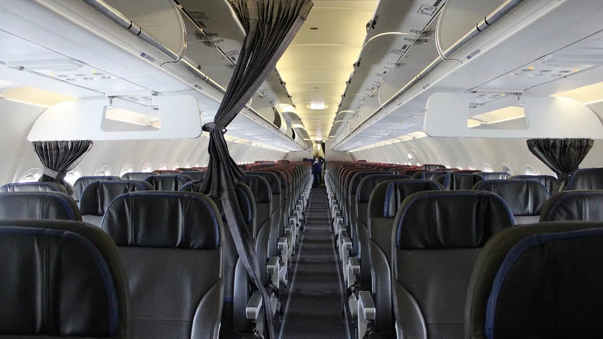 Interior de la cabina de un Airbus A320 de LATAM con filas de asientos vacíos