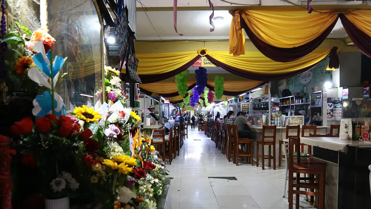 Pasillo del Mercado Central de Tacna con flores y puestos de comida