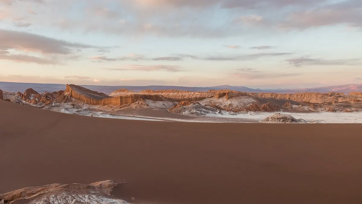 Gran duna de arena con filos de sal iluminados por el sol de la tarde